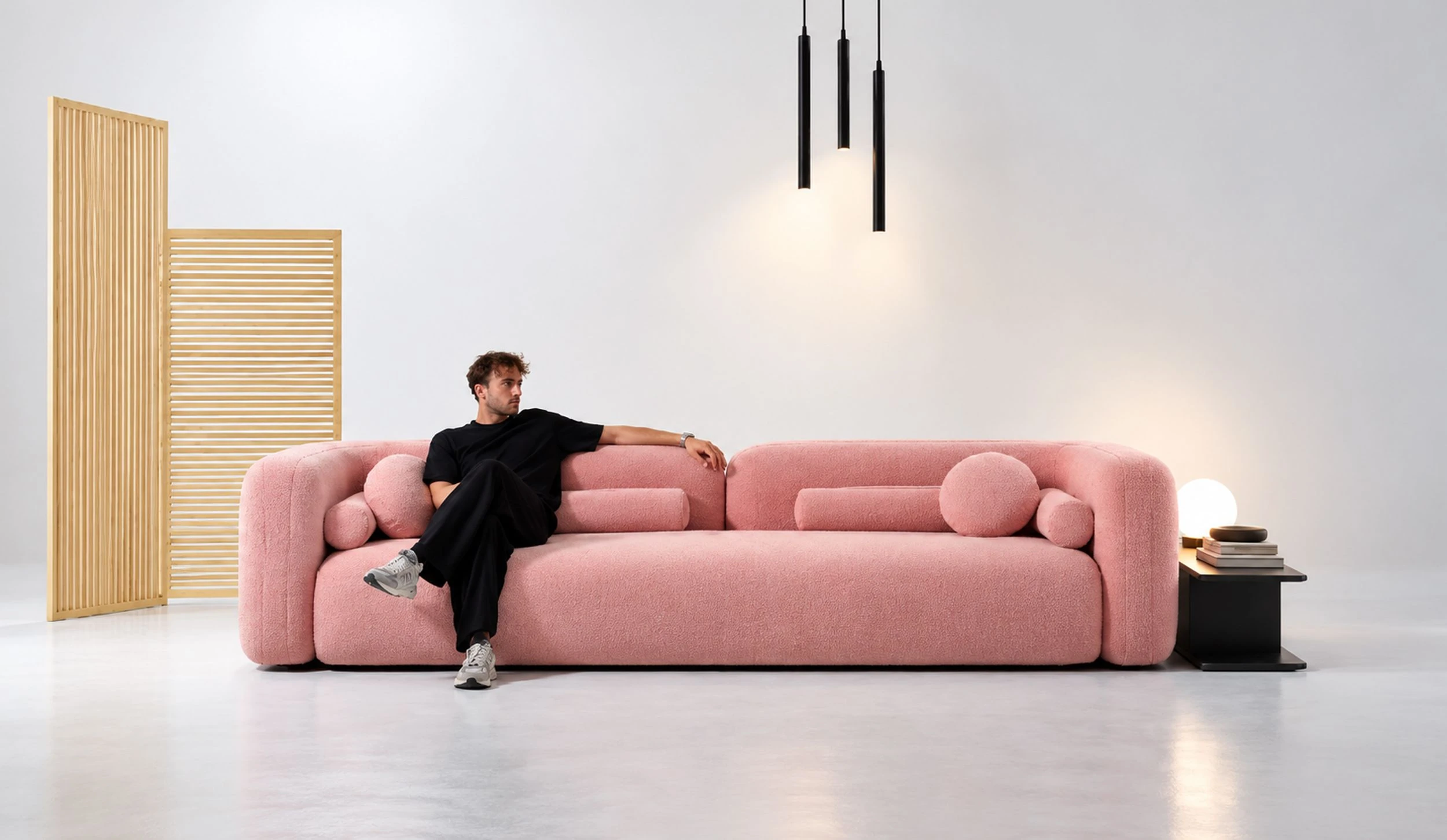 A man seated on a pink sofa